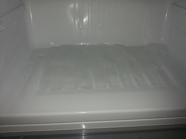 Лёд под нижней полкой морозильной камеры